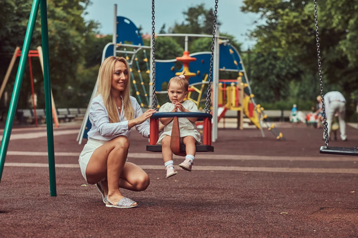 Mama mit ihrem Kind auf dem Spielplatz